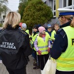 Na zdjęciu widać dzieci rozdające odblaski podczas akcji profilaktycznej