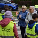 Na zdjęciu widać dzieci rozdające odblaski podczas akcji profilaktycznej