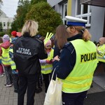Na zdjęciu widać dzieci rozdające odblaski podczas akcji profilaktycznej