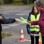 Na zdjęciu widać dzieci rozdające odblaski podczas akcji profilaktycznej