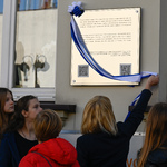 Nauczycielka zdejmuje wstęgę z tablicy upamiętniającej dzieci żydowskie z białostockiego getta