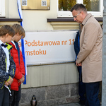 Dwóch chłopców i zastępca prezydenta Rafał Rudnicki stoją przy pamiątkowej tablicy