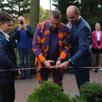 Dariusz Paczkowski i dyrektor Mariusz Sokołowski podczas przecinania wstęgi okalającej mural