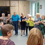 Seniorzy tańczą w kółku podczas zabawy