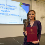 Studentka trzyma w dłoniach dyplom