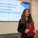 Studentka trzyma w dłoniach dyplom