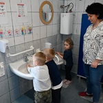 Dzieci myją ręce. Obok stoi nauczycielka