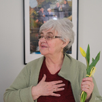 Seniorka trzyma w dłoni tulipana