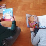 Na zdjęciu widać dwóch chłopców czytających bajkę
