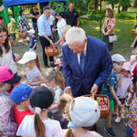 Prezydent Tadeusz Truskolaski częstuje dzieci owocami i słodkimi upominkami