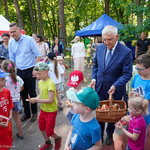 Prezydent Tadeusz Truskolaski częstuje dzieci owocami i słodkimi upominkami