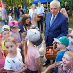 Prezydent Tadeusz Truskolaski częstuje dzieci owocami i słodkimi upominkami