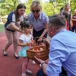 Zastępca prezydenta Rafał Rudnicki częstuje dziewczynkę słodkimi upominkami