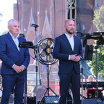 Przewodniczący Rady Miasta Białystok Łukasz Prokorym zabiera głos na scenie, obok stoi prezydent Tadeusz Truskolaski