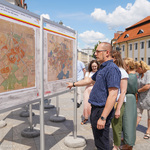 Mężczyzna ogląda wystawę urbanistyczną i wskazuje palcem na jedną z plansz