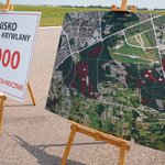 Dwie sztalugi z planszami. Na jednej znajduje się napis: Lotnisko Białystok - Krywlany 10 000 operacji lotniczych rocznie. Na drugiej została umieszczona mapa przedstawiająca plan urządzania lasów na Krywlanach