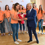 Prezydent Tadeusz Truskolaski wręcza bukiet kwiatów siatkarce