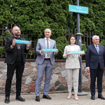 Prezydent Tadeusz Truskolaski, Swietłana Ciechanouska, Pavel Latushka oraz Artur Michalski pozują do pamiątkowego zdjęcia trzymając w dłoniach miniatury tablic z napisem Skwer Wolnej Białorusi