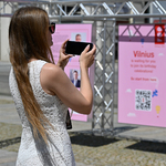 Młoda kobieta fotografuje wystawę telefonem
