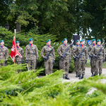 Żołnierze wraz z sztandarem stoją na baczność