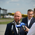 Przewodniczący Rady Miasta Białystok Łukasz Prokorym zabiera głos podczas konferencji na lotnisku Krywlany