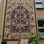 Kobiece dłonie trzymające miniaturkę muralu Nadzieja, w tle: mural 