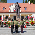 Pomnik Marszałka Józefa Piłsudskiego, przed pomnikiem stoi trzech salutujących mężczyzn 