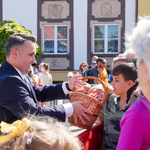 Zastępca prezydenta Przemysław Tuchliński częstuje białostoczan lizakami znajdującymi się w wiklinowym koszu 