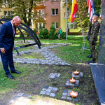 Przewodniczący Rady Miasta Łukasz Prokorym pochyla głowę oddając hołd pod pomnikiem 