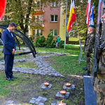 Mężczyzna pochyla głowę na znak oddania hołdu pod pomnikiem 