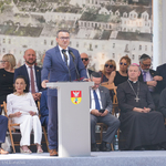 Mężczyzna zabiera głos podczas uroczystości, w tle: goście 