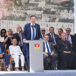 Mężczyzna zabiera głos podczas uroczystości, w tle: goście spotkania 