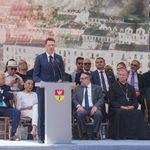 Mężczyzna przemawia z mównicy, w tle: goście honorowi 