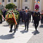 Prezydent Tadeusz Truskolaski w asyście strażników miejskich podąża w stronę pomnika