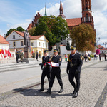 Strażnicy miejscy niosą flagę Polski 