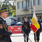 Komendant Straży Miejskiej Krzysztof Kolendo przemawia podczas uroczystości, w tle: poczet sztandarowy