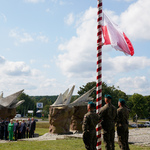 Żołnierze stoją przy maszcie, na którym została powieszona flaga Polski