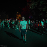 Zastępca prezydenta Adam Musiuk startujący z numerem 5963 podczas nocnej piątki pozuje do pamiątkowego zdjęcia, w tle: uczestnicy biegu