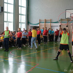 Zawodnicy podczas turnieju stoją w dwóch rzędach, osoby stojące na przodzie trzymają w dłoniach hula-hop. W tle: publiczność 