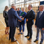 Mężczyzna odbiera gratulacje z rąk prezydenta Tadeusza Truskolaskiego, obok stoją nauczyciele 