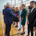 Krótko ścięta nauczycielka w sukience w kolorze butelkowej zieleni odbiera gratulacje z rąk prezydenta Tadeusza Truskolaskiego 