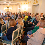 Uczestnicy spotkania siedzą na sali w Pałacyku Gościnnym