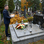 Zastępca prezydenta Rafał Rudnicki stoi nad grobem Wiesławy oraz Haliny Kazaneckich trzymając w dłoniach znicz 
