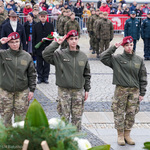 Trzy kobiety ubrane w mundury salutują podczas uroczystości