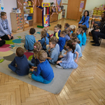 Dzieci siedzą na dywanie podczas spotkania