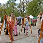 Dzieci podczas malowania na drewnianych sztalugach 