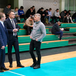 Zastępca prezydenta Rafał Rudnicki podczas rozmów na sali gimnastycznej. Na trybunach siedzą uczniowie