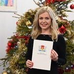Kobieta prezentuje otrzymany akt mianowania 