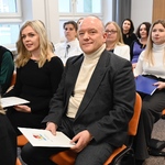 Nauczyciele siedzą na sali podczas uroczystości