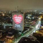 Budynek Urzędu Miejskiego w Białymstoku z iluminacją: czerwone serduszko z napisem: Wielka Orkiestra Świątecznej Pomocy oraz napisem: #Białystok gra z WOŚP. Widok z drona
